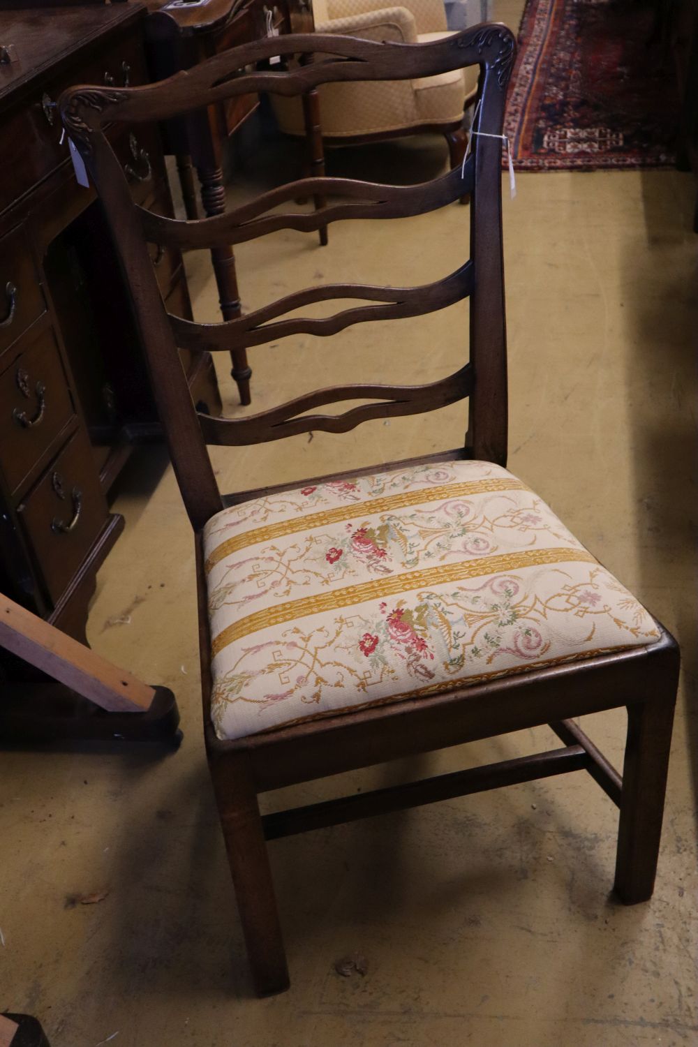 A set of three George III mahogany dining chairs with crewel-work seats and another set of three George III dining chairs (6)